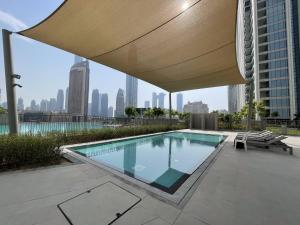 uma piscina com um grande guarda-sol no topo de um edifício em 3br Facing Dubai Mall 5 Min Walk To Burj Khalifa em Dubai