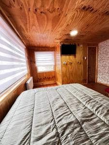 una cama grande en una habitación con ventana en Departamento La Escondida 1, en Puerto Natales