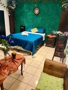 una camera con un letto blu e una parete verde di The Enchanted Forest a Antigua Guatemala