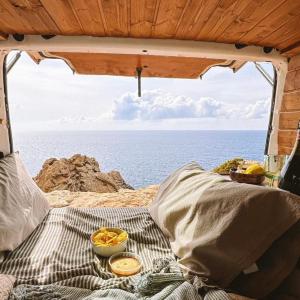 a bed in a tent with a view of the ocean at Van Camper Ibiza Volkswagen T4 Van Voyage in Ibiza Town