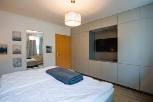 a bedroom with a large bed with a tv on the wall at Apartment "Heinz Ellmann" Rostock in Rostock
