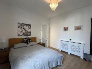 a bedroom with a bed and a chandelier at 2 Bedroom flat 10 min walk to tube in London