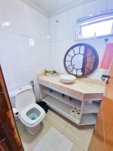 uma casa de banho com um WC, um lavatório e um espelho. em Cantinho em Diamantina