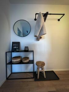 a mirror on a wall with a stool next to a shelf at Black Forest Home in Schönwald