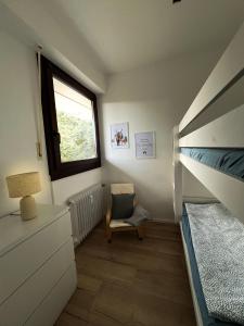 a small bedroom with a bunk bed and a chair at Black Forest Home in Schönwald