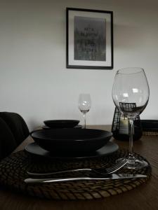 a table with a black plate and two wine glasses at Black Forest Home in Schönwald
