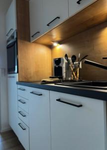 a kitchen with white cabinets and a stove top oven at Black Forest Home in Schönwald