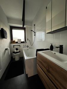 a bathroom with a tub and a sink and a toilet at Black Forest Home in Schönwald