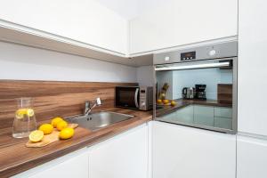 a kitchen with a sink and a microwave at Apartment Kozielska z pięknym ogrodem i tarasem in Gliwice
