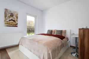 biała sypialnia z łóżkiem i oknem w obiekcie Apartment Kozielska z pięknym ogrodem i tarasem w mieście Gliwice