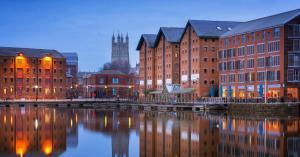 a group of buildings next to a river at Entire 3 bed house in Gloucester in Gloucester