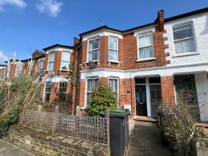 a brick house with a fence in front of it at 2 Bedroom flat 10 min walk to tube in London