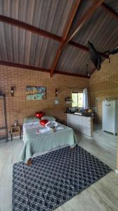 a bedroom with a bed and a brick wall at REFUGIO PIEMONTE Chalés in Socorro