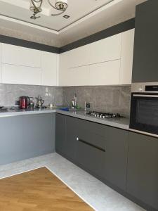 a kitchen with white cabinets and a stove top oven at Blue Residence Baku in Baku