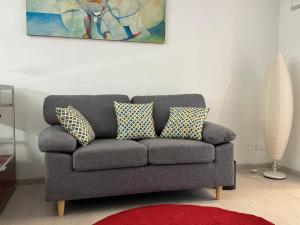 um sofá cinzento com almofadas numa sala de estar em Civico 45 em Ancona