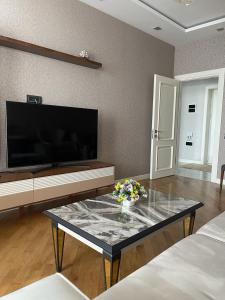 a living room with a table with flowers on it at Blue Residence Baku in Baku