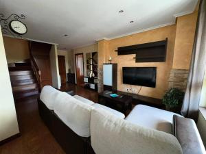sala de estar con sofás blancos y TV de pantalla plana en HOLYDAY HOME SUANCES en Suances