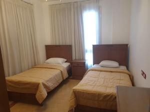 two beds in a hotel room with a window at Vacation villa in Sharm El Sheikh on the beach in Sharm El Sheikh