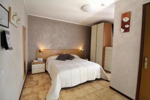 1 dormitorio con 1 cama con colcha blanca en Hotel Avogadro, en San Pellegrino Terme