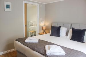 una camera da letto con un letto e due asciugamani di Sandcastles 15A Fore Street a Salcombe