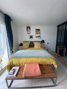 een slaapkamer met een groot bed en een tafel bij COSY ROOM PRIVATE BATH AND GARDEN in Anglet