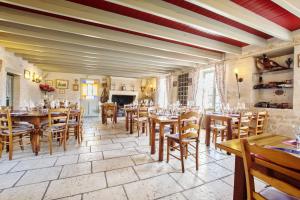 un restaurante con mesas de madera y sillas en una habitación en L'auberge'Inn, en Coulon