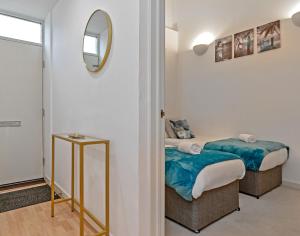 1 dormitorio con 2 camas y espejo en Stylish 2 bedroom apartment, 2 bathrooms, free parking for all guest, wifi, Sky, Netflix, walking distance to city centre, sleeps 5, outside patio space, ground floor en Milton Keynes