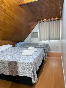 a bedroom with two beds with towels on them at Casa em Condominio próximo trevo Cataratas em Cascavel in Cascavel