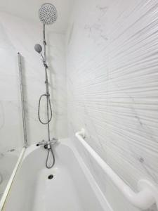 een witte badkamer met een douche en een bad bij Three Bed Flat In Mile End in Londen