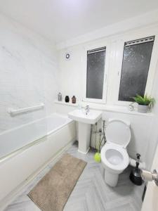 een witte badkamer met een toilet en een wastafel bij Three Bed Flat In Mile End in Londen