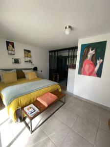 a bedroom with a bed and a painting on the wall at COSY ROOM PRIVATE BATH AND GARDEN in Anglet