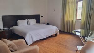 1 dormitorio con 1 cama grande y 2 sillas en Sori Apartments en Lima