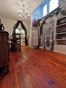 un soggiorno con pavimento in legno massello e lampadario pendente. di Suite privative Le seigneur des Anneaux Arnor a Vertaizon