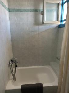 a bath tub in a bathroom with a window at Matina Naxos - Mikri Vigla in Mikri Vigla