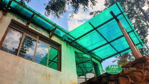 Bamasaba Community Lodge في Mbale: عماره خضراء امامها لافته