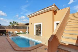een villa met een zwembad en een huis bij Villa Corralejo in Corralejo
