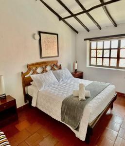 Un dormitorio con una gran cama blanca y una ventana en Hotel-Apartahotel Boutique Piedra & Luna, en Villa de Leyva