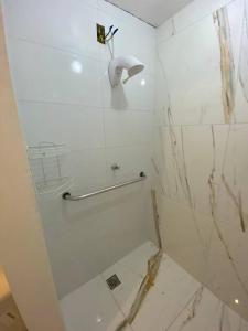 uma casa de banho branca com um chuveiro com uma porta de vidro em Casa em Condominio próximo trevo Cataratas em Cascavel em Cascavel