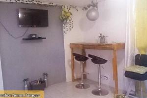 a room with a table and stools and a television at stay vacation home curaçao in Willemstad