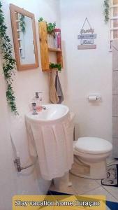 a bathroom with a white sink and a toilet at stay vacation home curaçao in Willemstad