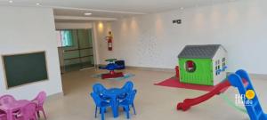 um quarto com cadeiras e uma televisão e uma casa de jogos em Thel Ubatuba - Apto 48/A, Saint Martin em Ubatuba