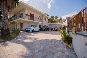 un parking avec des voitures garées devant un bâtiment dans l'établissement Villa Marchese, à Trecastagni