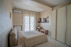 ein Schlafzimmer mit einem weißen Bett und einem Fenster in der Unterkunft Villa Marchese in Trecastagni