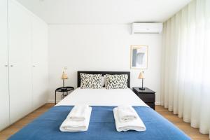 um quarto com uma cama grande e um cobertor azul em António Marinho by House and People em Braga