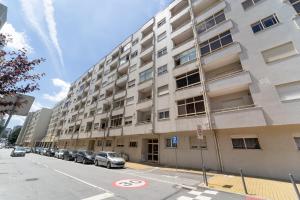 um prédio de apartamentos com carros estacionados em frente em António Marinho by House and People em Braga