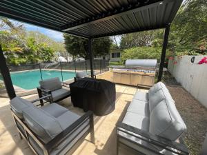 a covered patio with chairs and a swimming pool at Family 4br Home Near Dadeland Mall in Miami