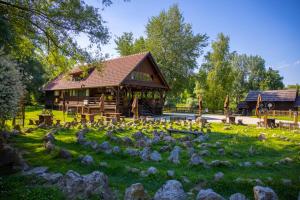 eine Blockhütte mit Felsen im Gras in der Unterkunft Chill Hill House in Sveti Martin na Muri