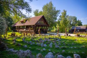 a log cabin with rocks in the grass at Chill Hill House in Sveti Martin na Muri