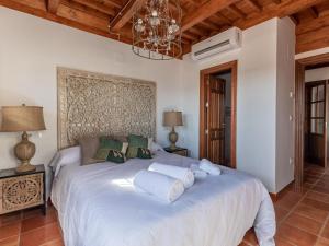 Un dormitorio con una gran cama blanca con una lámpara de araña. en Luxury Alhambra Penthouse Collection Sacromonte, en Granada
