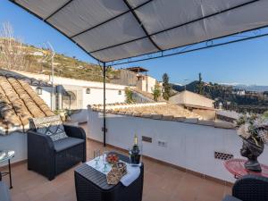 een patio met een tafel en stoelen op een dak bij Alhambra Luxury Albaicin in Granada